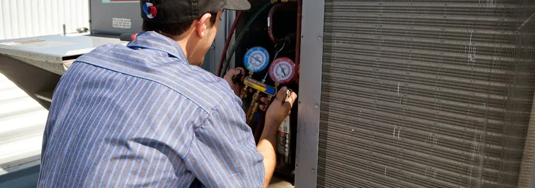HVAC technician servicing a condenser unit in Siesta Key